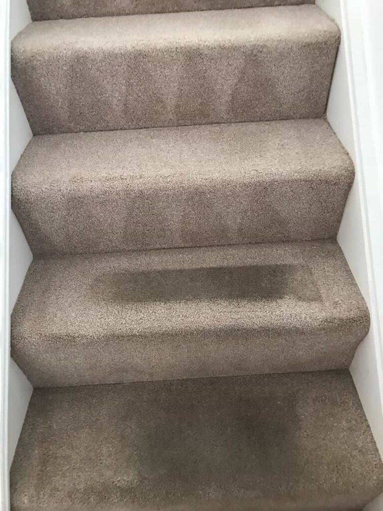 this is a photo of a staircase with beige carpets that is in the process of being cleaned works carried out by Mill Hill Carpet Cleaning.